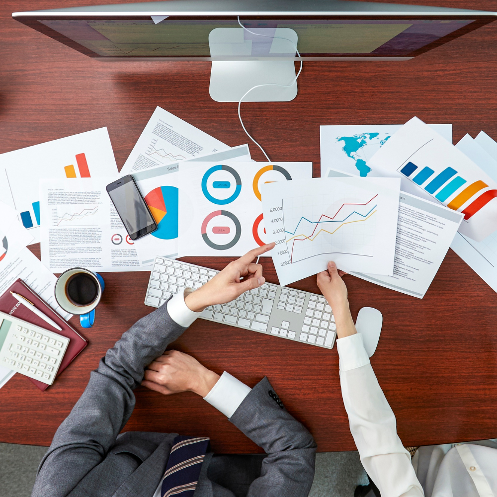 Stacks of financial reports and audit sheets laid out for review,symbolizing Twinline.org's Business Correspondence module used for partner performance monitoring, compliance tracking, and data-driven decision-making.