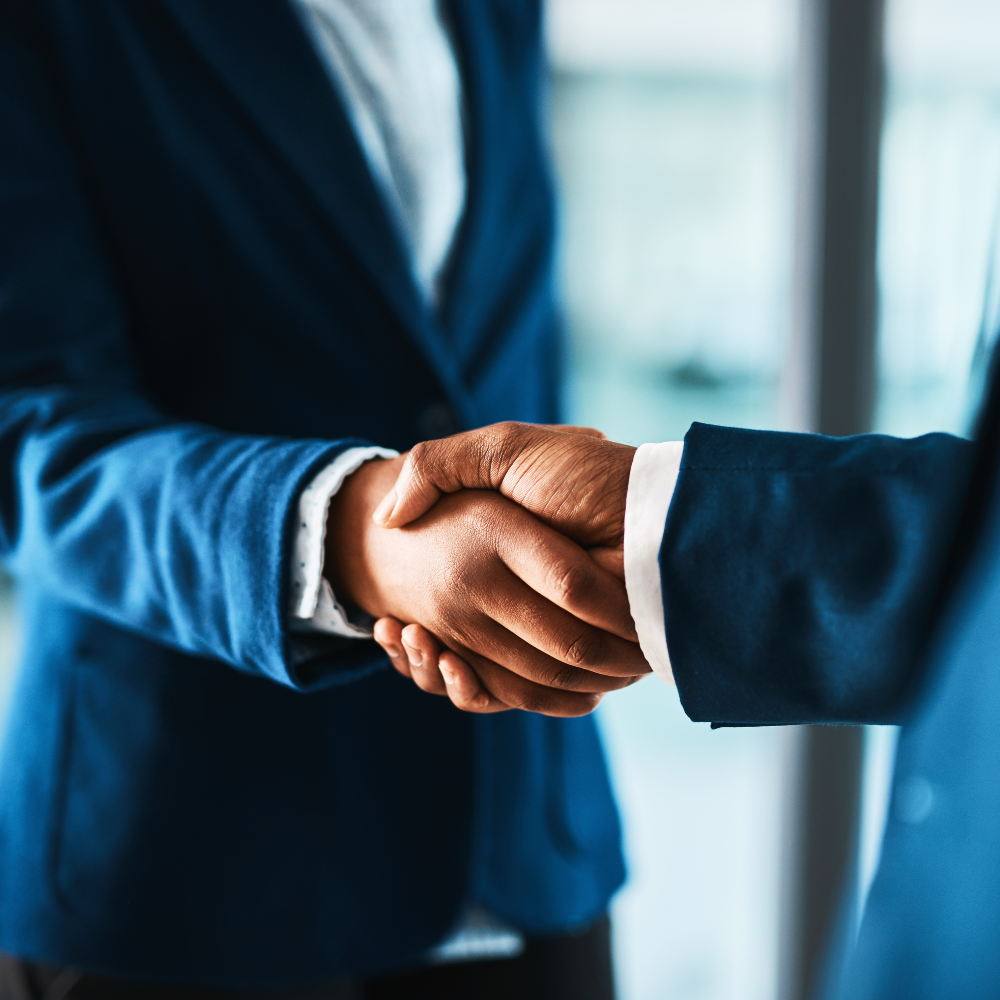 Two individuals shaking hands, representing Twinline.org's co-lending module for collaborative lending between financial institutions