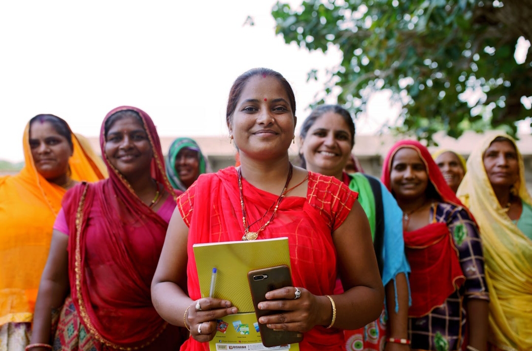 A group of cheerful rural women walking together after completing a GRT / CGT meeting, empowered and excited to begin their journey with Joint Group Lending facilitated by NBFCs and MFIs using Twinline.org's digital platform.
